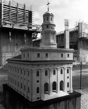 A model of the Nauvoo Temple sits in front of the real one under construction